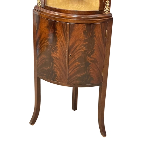 1015 - A mahogany bow front corner cabinet with brass ormolu mounts on splayed feet. 52x34x171.5cm (3)