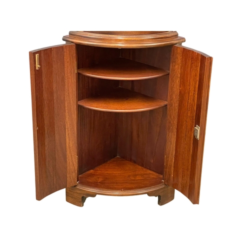 1016 - A mahogany bow front corner cabinet with brass ormolu mounts. 55x37x169.5cm (3)