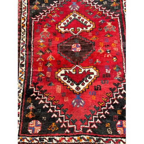 1129 - A vintage Iranian hand knotted rug. The Persian Rug Company. 83x121cm