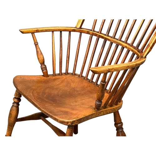 1168 - A mid 19th century elm and beech Windsor armchair. (6)