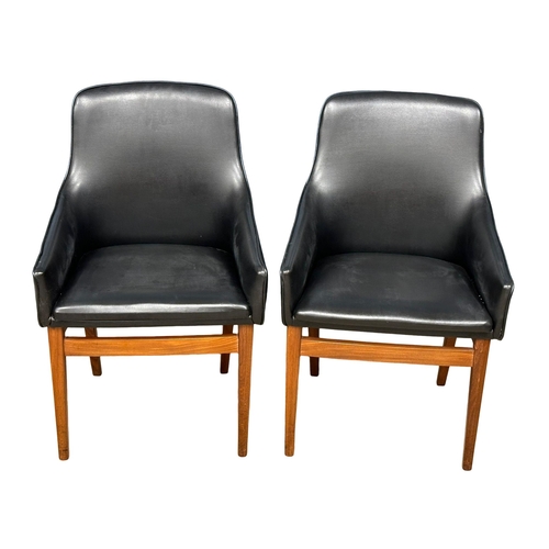 852 - A pair of good quality Mid Century teak and black vinyl armchairs. 1960’s. (8)