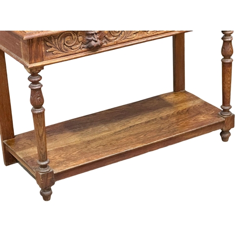 873 - A Victorian oak gallery back side table with carved Man of the Forest drawer. 105x47x105cm (5)