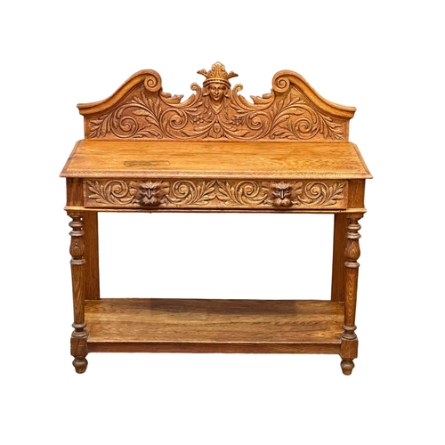 873 - A Victorian oak gallery back side table with carved Man of the Forest drawer. 105x47x105cm (5)