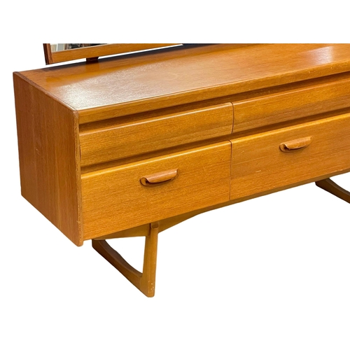 887 - A Mid Century teak dressing table by William Lawrence. 156x41x115cm (10)