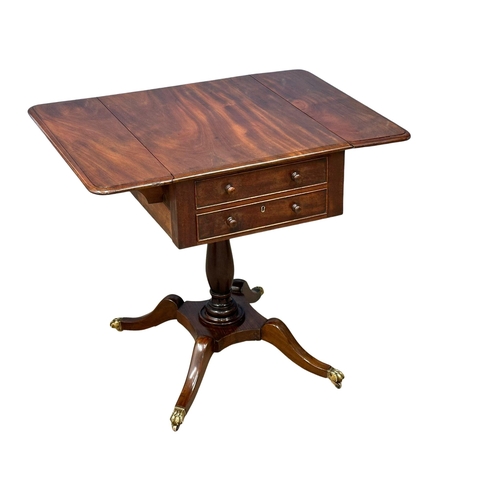 927 - A Regency mahogany double sided pedestal drop leaf table on brass lion paw feet. Circa 1810. 82x61x7... 