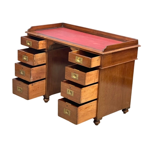 941 - A Victorian mahogany gallery back campaign desk with leather top. (13)