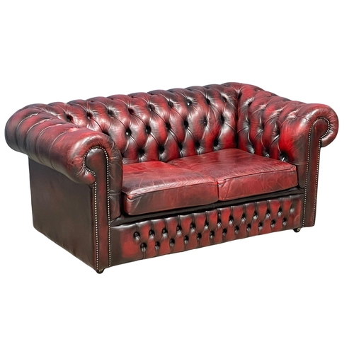 944 - An ox-blood leather deep button 2 seater sofa. 153cm (12)