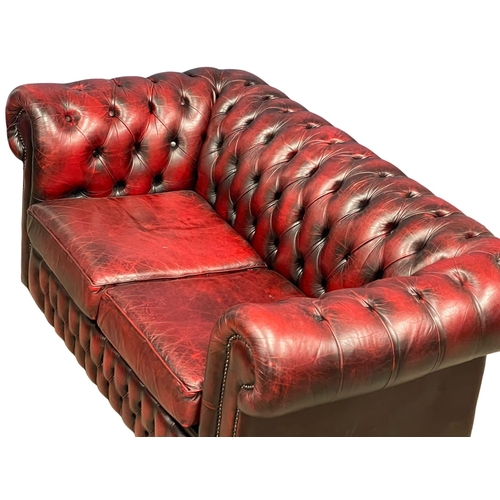 944 - An ox-blood leather deep button 2 seater sofa. 153cm (12)