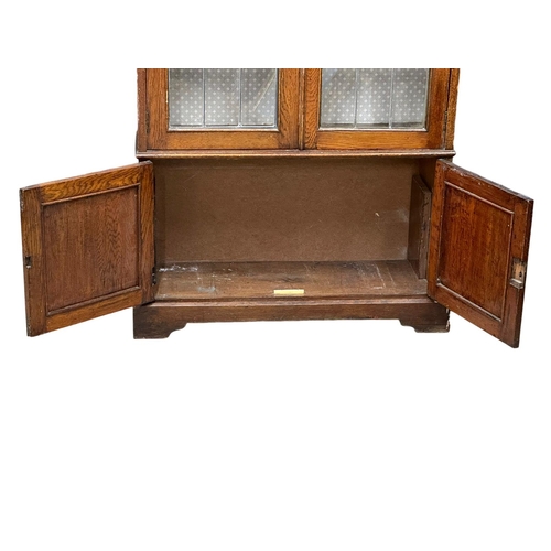 948 - A large early 20th century oak bookcase with stained glass doors and fitted shelves. Circa 1920-1930... 