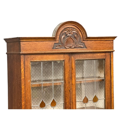 948 - A large early 20th century oak bookcase with stained glass doors and fitted shelves. Circa 1920-1930... 