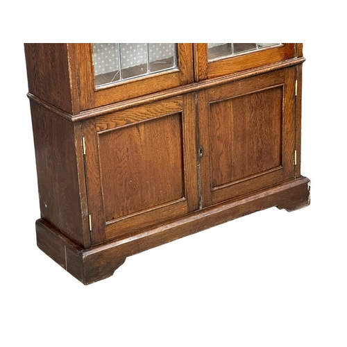 948 - A large early 20th century oak bookcase with stained glass doors and fitted shelves. Circa 1920-1930... 