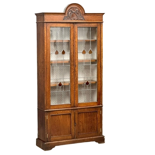 948 - A large early 20th century oak bookcase with stained glass doors and fitted shelves. Circa 1920-1930... 