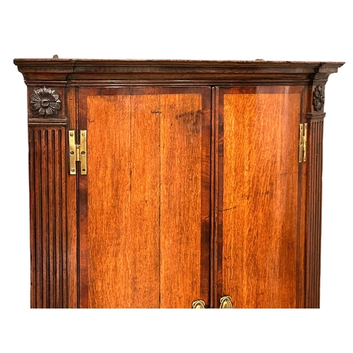 992 - A good quality early George III oak wall hanging corner cabinet with mahogany crossbanding, brass ‘H... 