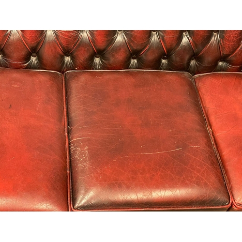 1202 - An ox-blood deep button leather 3 seater sofa. 197cm. (10)