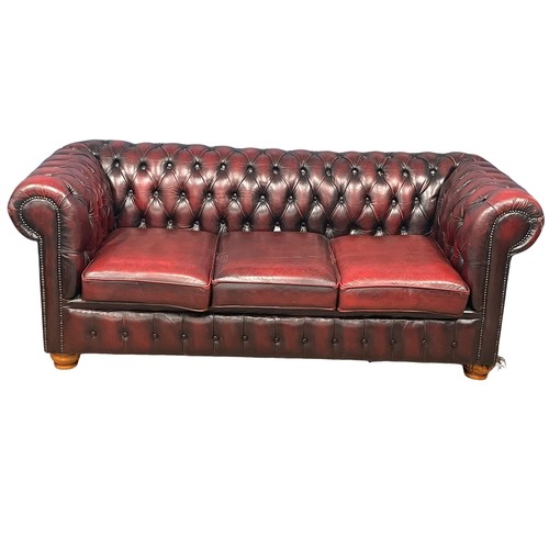 1202 - An ox-blood deep button leather 3 seater sofa. 197cm. (10)