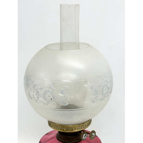 2 - A late Victorian brass oil lamp with Ruby Glass bowl. 55cm