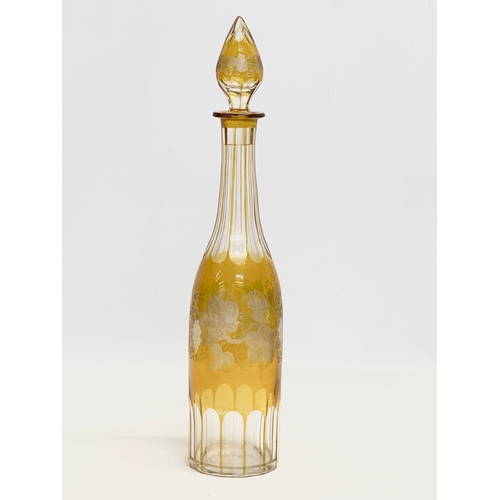 36 - A tall early 20th century Bohemian amber stained and cut glass decanter with engraved flower and gra... 