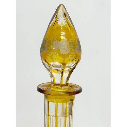 36 - A tall early 20th century Bohemian amber stained and cut glass decanter with engraved flower and gra... 