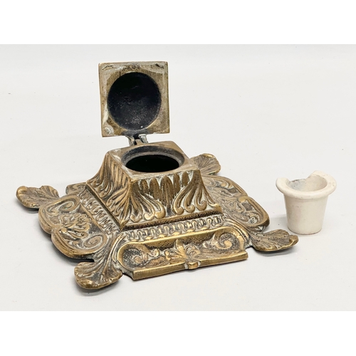 79 - An early 20th century ornate brass inkwell with liner. 16x16x8cm