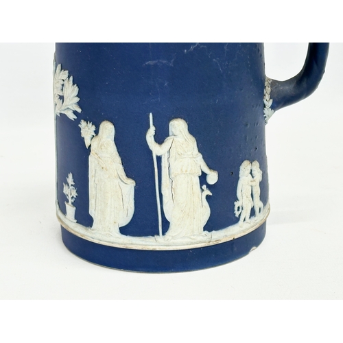 88 - 4 pieces of late 19th century Wedgwood Jasper Ware. A pair of jugs 17x19.5cm. A pair of cylinder vas... 