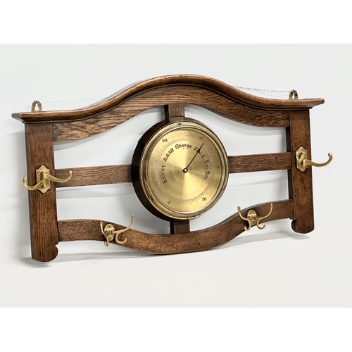 246 - An early 20th century oak wall hanging barometer/hat and coat rack. 78x43cm