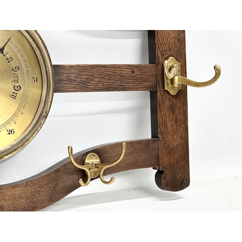 246 - An early 20th century oak wall hanging barometer/hat and coat rack. 78x43cm