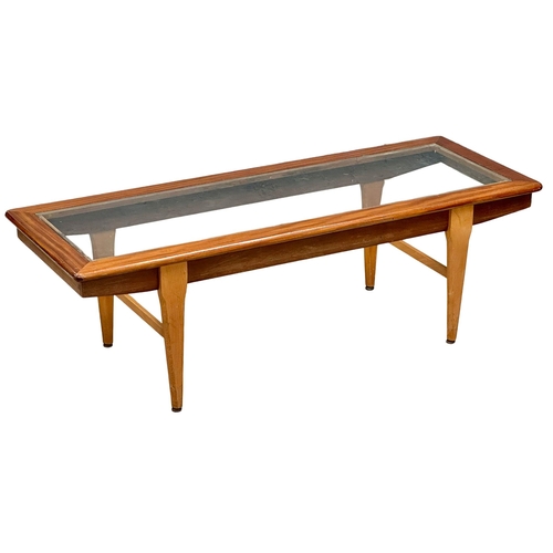 948 - A Mid Century teak coffee table with glass top. 121x46x39cm