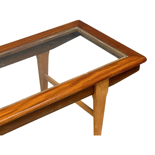 948 - A Mid Century teak coffee table with glass top. 121x46x39cm