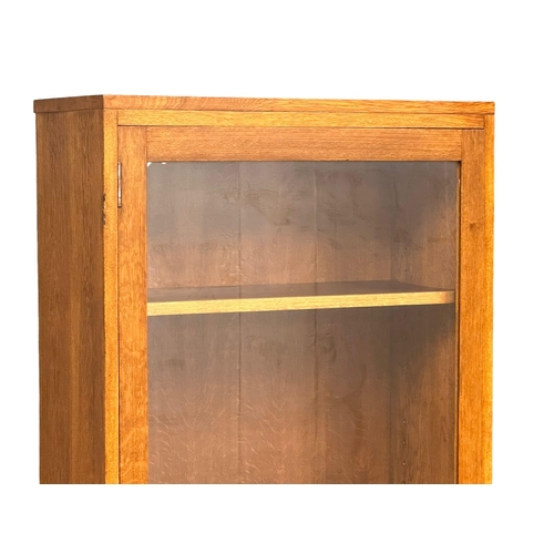 952 - A large vintage oak glazed door cabinet with adjustable shelves. 69x32x84cm