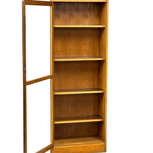 952 - A large vintage oak glazed door cabinet with adjustable shelves. 69x32x84cm