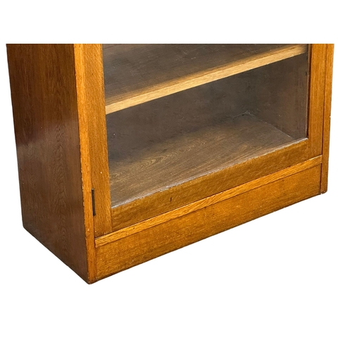 952 - A large vintage oak glazed door cabinet with adjustable shelves. 69x32x84cm