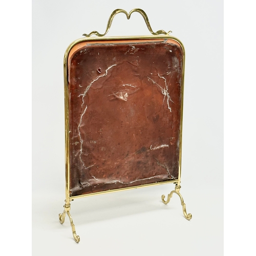 27 - An Edwardian brass framed firescreen with painted mirror. 43x19x69cm
