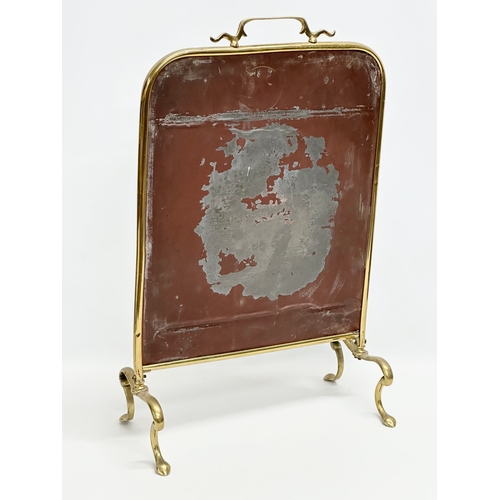 28 - An Edwardian brass framed firescreen with painted mirror. 38x20x59cm