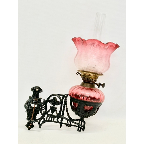 56 - A Victorian wall bracket oil lamp with Ruby Glass bowl and shade. 34x50cm
