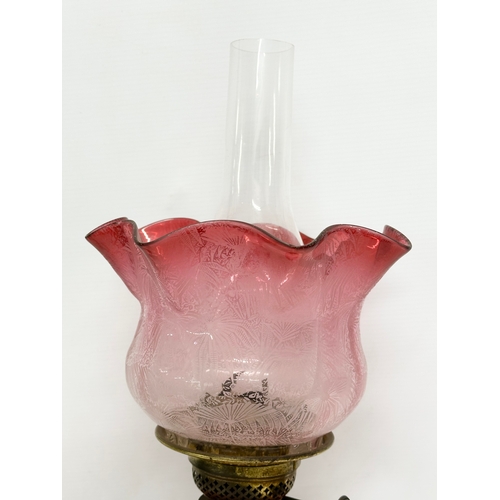 56 - A Victorian wall bracket oil lamp with Ruby Glass bowl and shade. 34x50cm