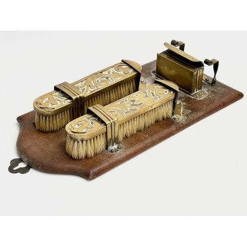 376 - An Art Nouveau brass wall hanging clothes brush set on leather bound panel. Circa 1900. 17x35cm