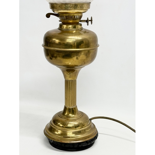 360 - A large early 20th century brass electrified oil lamp with glass shade. 61cm