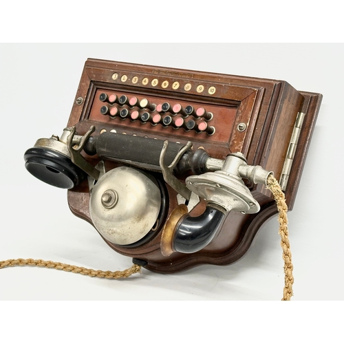 358 - An early 20th century wall mounted telephone. British Manufacturer. 26x19x16cm