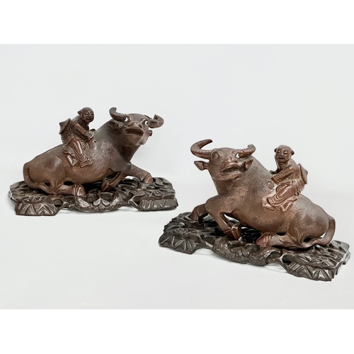 162 - A pair of early 20th century Chinese carved Water Buffalo’s with riders on stands. 26x12x16cm