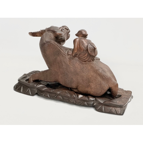 162 - A pair of early 20th century Chinese carved Water Buffalo’s with riders on stands. 26x12x16cm