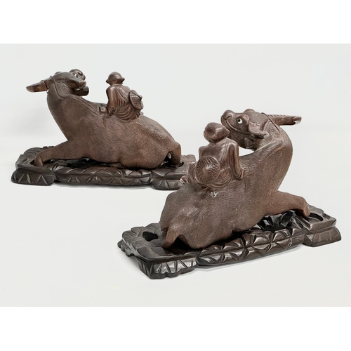 162 - A pair of early 20th century Chinese carved Water Buffalo’s with riders on stands. 26x12x16cm