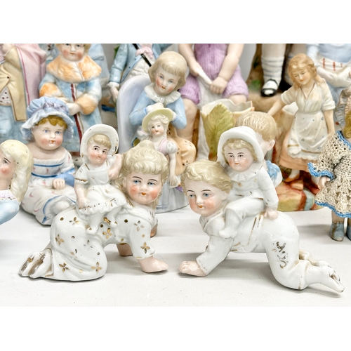 279 - A large collection of late 19th and early 20th century German Bisque figurines. Largest pair 43cm. 3... 