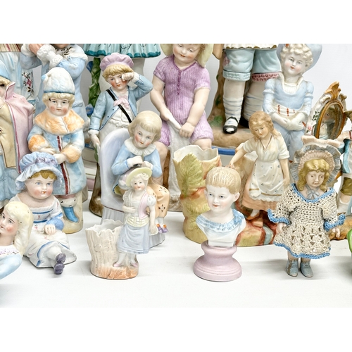 279 - A large collection of late 19th and early 20th century German Bisque figurines. Largest pair 43cm. 3... 