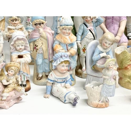 279 - A large collection of late 19th and early 20th century German Bisque figurines. Largest pair 43cm. 3... 