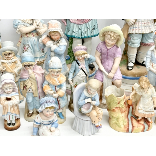 279 - A large collection of late 19th and early 20th century German Bisque figurines. Largest pair 43cm. 3... 