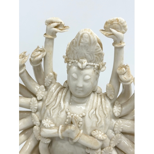 106 - A 20th century Chinese praying Guanyin figure with multiple arms on lotus leaves. 25cm