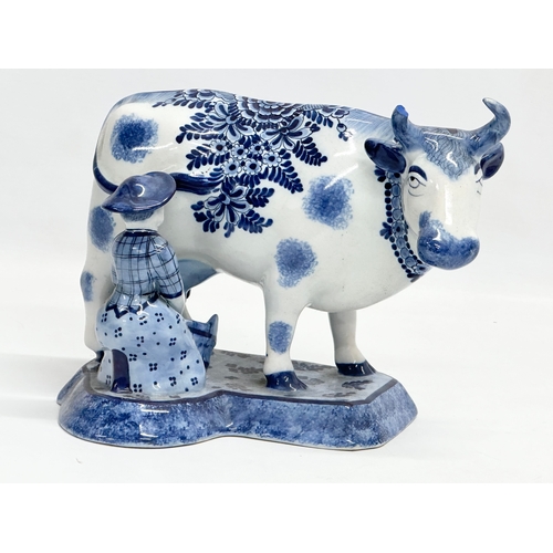 144 - A 19th century Dutch Delft ware Maid Milking the Cow figure. 22x14x17.5cm