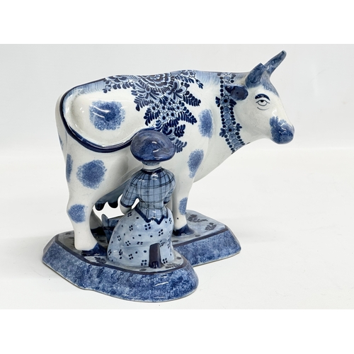 144 - A 19th century Dutch Delft ware Maid Milking the Cow figure. 22x14x17.5cm