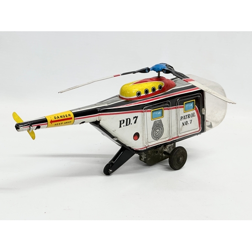 567 - A vintage tin plate police patrol helicopter. 26cm