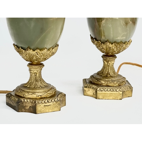 18 - A pair of excellent quality early 20th century gilt brass and onyx table lamps with rams head masks,... 